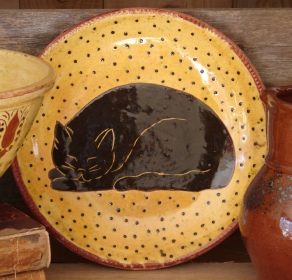 redware plate, sleeping black cat