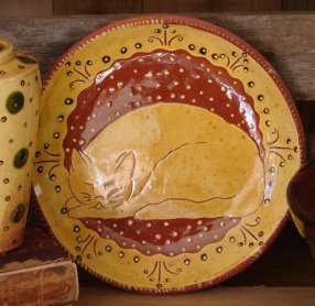 redware plate, sleeping white cat